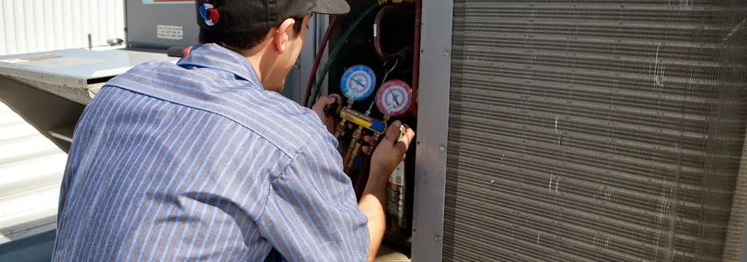 HVAC technician servicing a condenser unit in South Bend