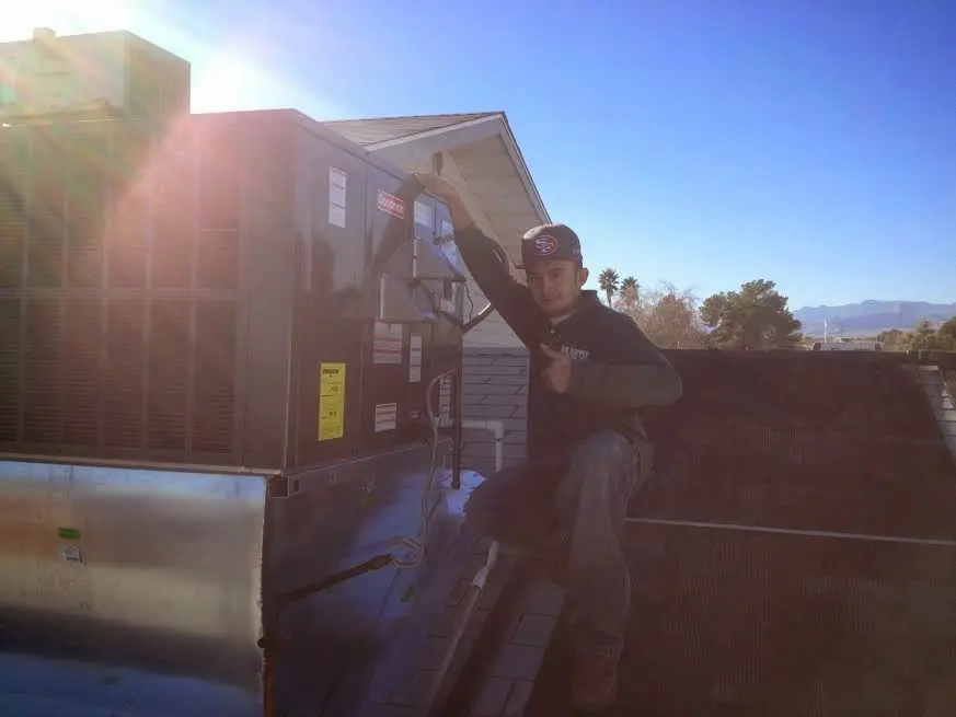 HVAC technician performing Air Duct Repair on a rooftop unit in South Bend